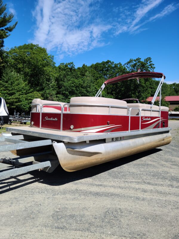 A red and white boat is parked on the street