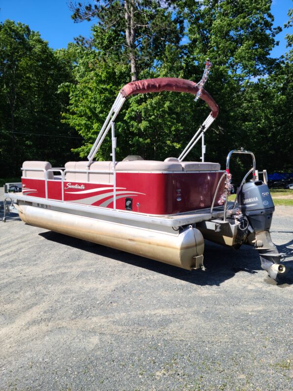 A red and white boat is parked on the ground