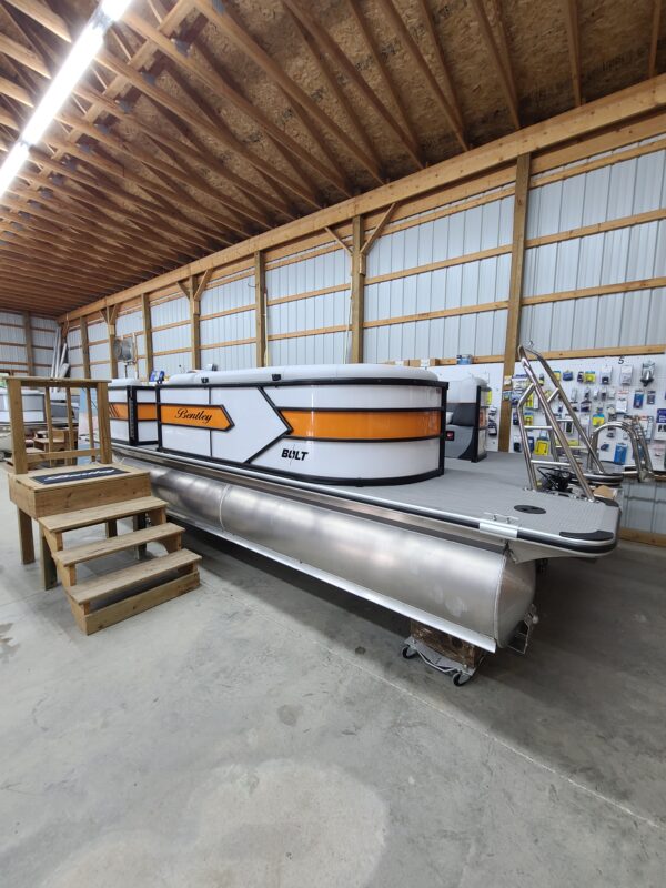 A large boat in a warehouse with some stairs.