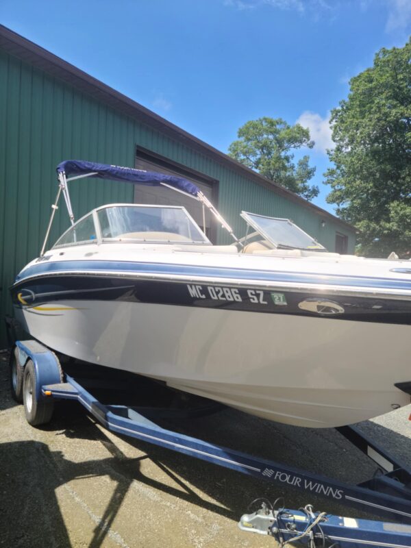 A boat is parked in the driveway of a house.