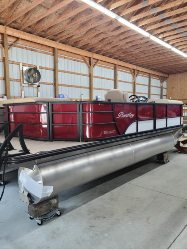 A large red boat sitting in a warehouse.