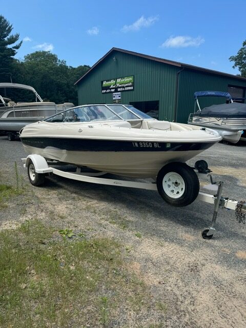 A boat parked in the parking lot of a garage.