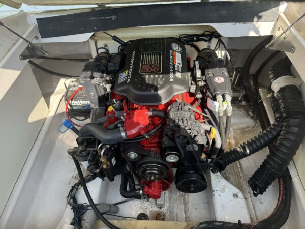 A boat with the engine exposed and some wires attached to it.