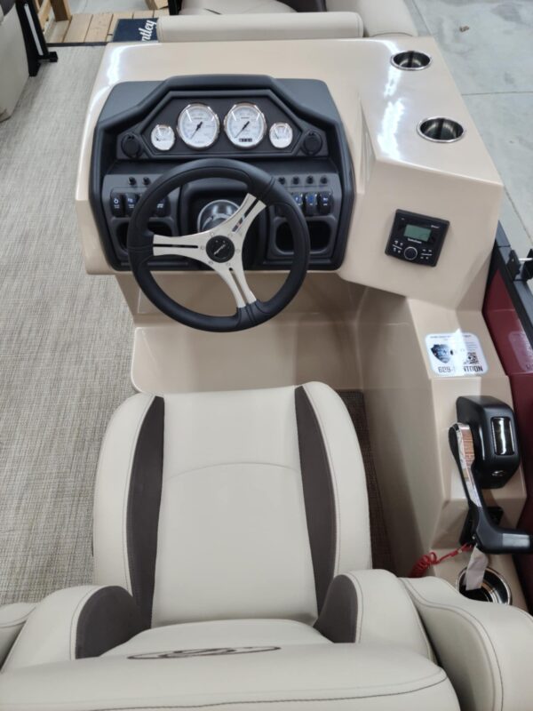 A boat with steering wheel and dashboard in the back.