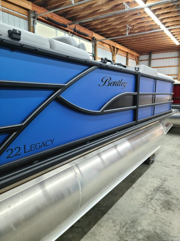 A blue and black boat is parked in a warehouse.