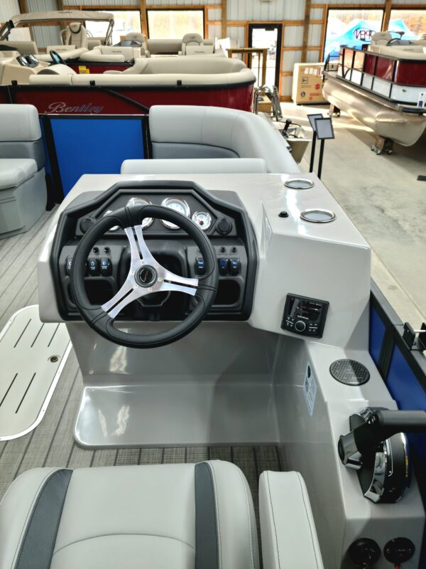 A boat with steering wheel and controls on the back.