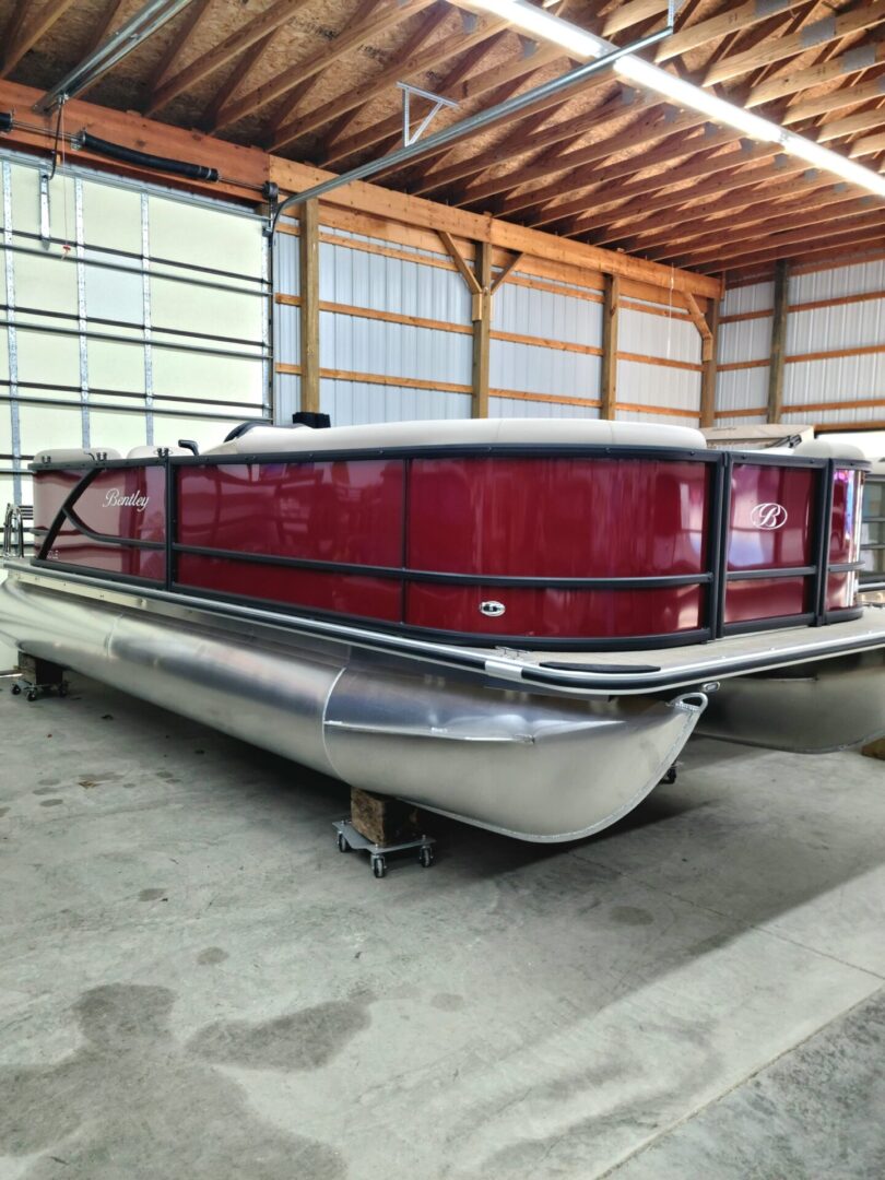 A red and silver boat in a warehouse.